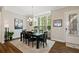 Dining room featuring a dark wood table and chairs, chandelier, large window, and hardwood floors at 938 Catamaran Ct, Alpharetta, GA 30005