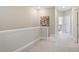 Upstairs hallway featuring neutral carpet, paint, and trim. View to bedroom at 938 Catamaran Ct, Alpharetta, GA 30005