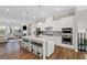 Open-concept kitchen with granite island, stainless steel appliances, and seamless connection to the living area at 938 Catamaran Ct, Alpharetta, GA 30005