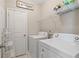 Bright laundry room featuring a washer, dryer, shelving, and convenient access door at 938 Catamaran Ct, Alpharetta, GA 30005
