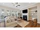 Comfortable living room featuring a fireplace, large windows, and hardwood floors at 938 Catamaran Ct, Alpharetta, GA 30005