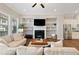 Cozy living room with a fireplace, built-in shelves, and view into kitchen at 938 Catamaran Ct, Alpharetta, GA 30005