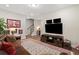 Inviting living room with a cozy leather sofa, media center, and staircase access at 938 Catamaran Ct, Alpharetta, GA 30005