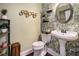 Stylish half bath with unique wallpaper, pedestal sink, and decorative mirror at 1950 Lancaster Se Dr, Conyers, GA 30013