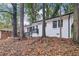 Charming white brick home with black trim and stairs nestled among mature trees and seasonal foliage at 2804 Dearwood Sw Dr, Atlanta, GA 30315