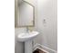 Well-lit half-bathroom with a pedestal sink, stylish faucet, and a framed mirror, perfect for guests at 309 Vista Ln, Woodstock, GA 30189