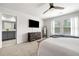 Bedroom with adjacent bathroom, ceiling fan, carpet, and view of backyard at 309 Vista Ln, Woodstock, GA 30189