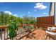 Inviting wooden deck with seating, potted plants, and a view of lush greenery and blue skies at 309 Vista Ln, Woodstock, GA 30189