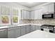 Modern kitchen featuring gray cabinets, stainless steel appliances, and mosaic tile backsplash at 309 Vista Ln, Woodstock, GA 30189