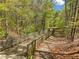 Scenic wooden walking path meanders through a lush, green wooded area on a sunny day at 309 Vista Ln, Woodstock, GA 30189
