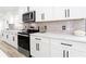 Close up of kitchen with white cabinets, stainless appliances and stylish backsplash at 4506 Dorset Dr, Decatur, GA 30035