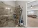 Bathroom featuring a tiled walk-in shower, a storage rack, and an open view to the bedroom at 6088 Holly Park Se Ln, Mableton, GA 30126