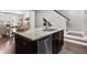 Granite island with stainless steel dishwasher in this kitchen, with seating, in an open concept home at 6088 Holly Park Se Ln, Mableton, GA 30126