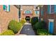 Brick building exterior with a pathway lined with green bushes leading to an arched entryway at 6088 Holly Park Se Ln, Mableton, GA 30126