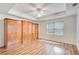 Sun-filled bedroom featuring hardwood floors, ceiling fan and decorative built-in wardrobes at 1900 Denton Walk Ct, Marietta, GA 30062