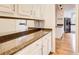 Butler's pantry with granite countertops, white cabinets, gold handles and modern pendant lighting at 1900 Denton Walk Ct, Marietta, GA 30062