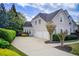 Well-manicured lawn and garden beds, exterior elevation with three-car garage and landscaping at 1900 Denton Walk Ct, Marietta, GA 30062