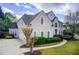 Angle view of a bright two-story home and driveway, with a manicured lawn and lush landscaping at 1900 Denton Walk Ct, Marietta, GA 30062
