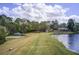 Sprawling green lawn next to a community lake with a playground and pavilion at 1900 Denton Walk Ct, Marietta, GA 30062