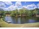 Scenic community pond view featuring a small dock and surrounded by mature trees at 1900 Denton Walk Ct, Marietta, GA 30062