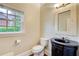 Stylish powder room with a black vanity, unique mirror, and window at 1900 Denton Walk Ct, Marietta, GA 30062