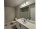 Bright bathroom with a single sink vanity and a large mirror reflecting the shower and toilet at 5576 Rockfern Drive, Lilburn, GA 30047