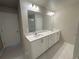 Bathroom featuring white double sink vanity and white countertops at 5576 Rockfern Drive, Lilburn, GA 30047