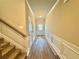 Hallway features wood-look flooring, white wainscoting, neutral paint, and access to the staircase at 5576 Rockfern Drive, Lilburn, GA 30047