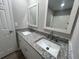 Bathroom featuring dual sinks with granite countertop and mirrors at 5961 Sherwood Trce, Stonecrest, GA 30038