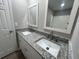 Bathroom with a dual sink vanity featuring granite countertops and white cabinets at 5961 Sherwood Trce, Stonecrest, GA 30038