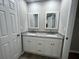Bathroom with a dual sink vanity featuring granite countertops and white cabinets at 5961 Sherwood Trce, Stonecrest, GA 30038
