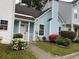 Exterior shot of light blue townhome featuring a black roof and a landscaped yard at 5961 Sherwood Trce, Stonecrest, GA 30038
