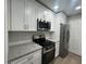 Modern kitchen features white cabinets, stainless steel appliances and granite countertops at 5961 Sherwood Trce, Stonecrest, GA 30038