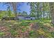 Serene backyard view showcasing mature trees, a lush lawn, and a screened-in porch at 8304 Ephesus Church Rd, Villa Rica, GA 30180