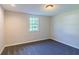 Sunlit bedroom with plush carpet and a window overlooking the green surroundings at 8304 Ephesus Church Rd, Villa Rica, GA 30180