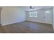 Bright living room with wood-look flooring, ceiling fan, and natural light from a window at 8304 Ephesus Church Rd, Villa Rica, GA 30180