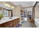 Bathroom with double sinks, dark wood cabinets and views of the main bedroom and walk-in bathtub at 2384 Allsborough Way, Dacula, GA 30019