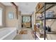 Bathroom showcases a soaking tub, a vanity, and open shelving for storage and decor at 2384 Allsborough Way, Dacula, GA 30019