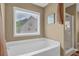 Serene bathroom featuring a soaking tub, a separate shower, and a window for natural light at 2384 Allsborough Way, Dacula, GA 30019