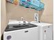 Laundry room with Maytag washer and dryer appliances, shelving above, and neutral-colored walls at 2384 Allsborough Way, Dacula, GA 30019