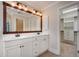 Bathroom with double sinks, decorative mirror, and walk-in closet access at 3085 Woodbridge Ln, Canton, GA 30114