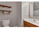 Cozy bathroom features a mirror, vanity, toilet and decorative shelving above toilet at 3085 Woodbridge Ln, Canton, GA 30114