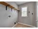 Practical laundry area with shelving, tile flooring, a window, and washer/dryer hookups at 3085 Woodbridge Ln, Canton, GA 30114