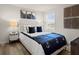 This cozy bedroom has a large window and is decorated with stylish furniture and wall art at 847 Pensive Run, Dacula, GA 30019