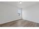 A well lit bedroom with wood-look flooring, neutral paint, and a double hung window at 847 Pensive Run, Dacula, GA 30019