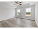 Spacious bedroom with tray ceiling, neutral walls, wood-look floors, and bright double windows at 847 Pensive Run, Dacula, GA 30019