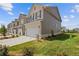 Exterior view of townhomes with green lawns, manicured bushes, and ample parking space at 847 Pensive Run, Dacula, GA 30019