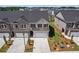 Aerial front view of townhomes with brick and siding, garages, and well-kept lawns at 847 Pensive Run, Dacula, GA 30019