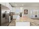 Well-lit kitchen with granite countertops, stainless appliances, an island, and access to the outdoor space at 847 Pensive Run, Dacula, GA 30019