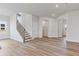 Bright living room with wooden floors, large windows, and a staircase with iron railing at 847 Pensive Run, Dacula, GA 30019